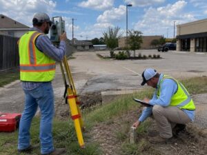 nearby surveyors examining an old boundary marker on a complex property in Mesquite Texas